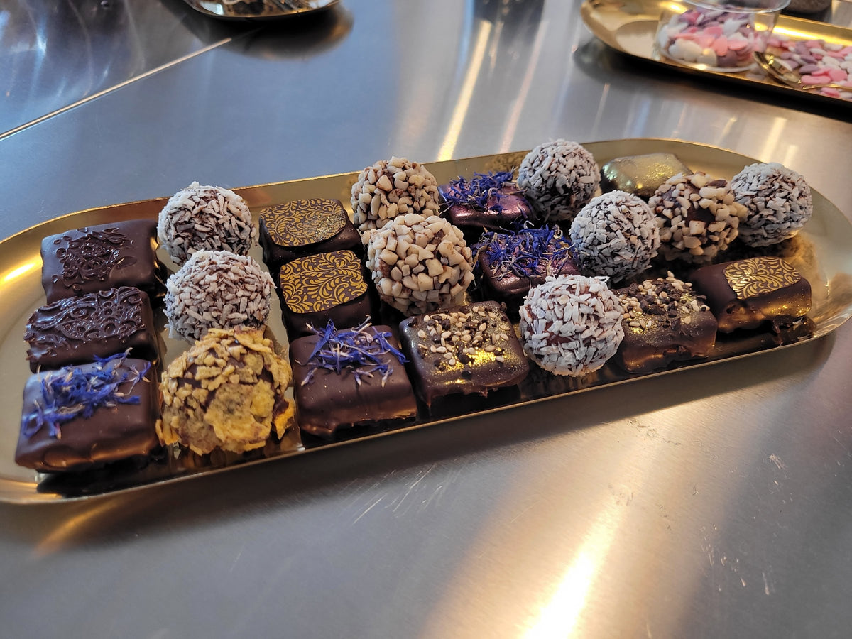 Gemischtes Sortiment aus Pralinen und Trüffeln auf einem Goldtablett nach dem Workshop