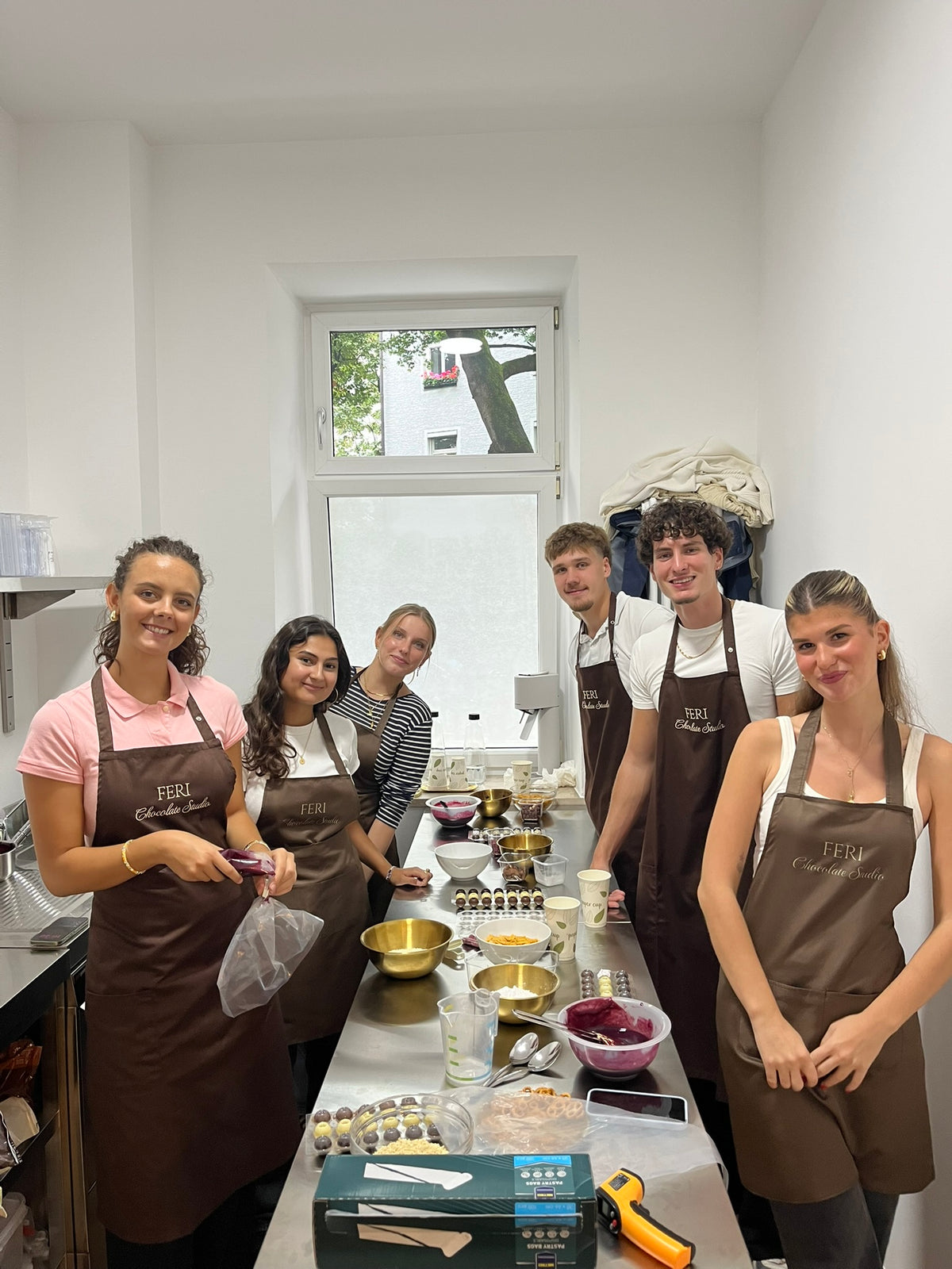 Kleinere Gruppe des Firmen-Teams mit fertigen Pralinen beim Workshop