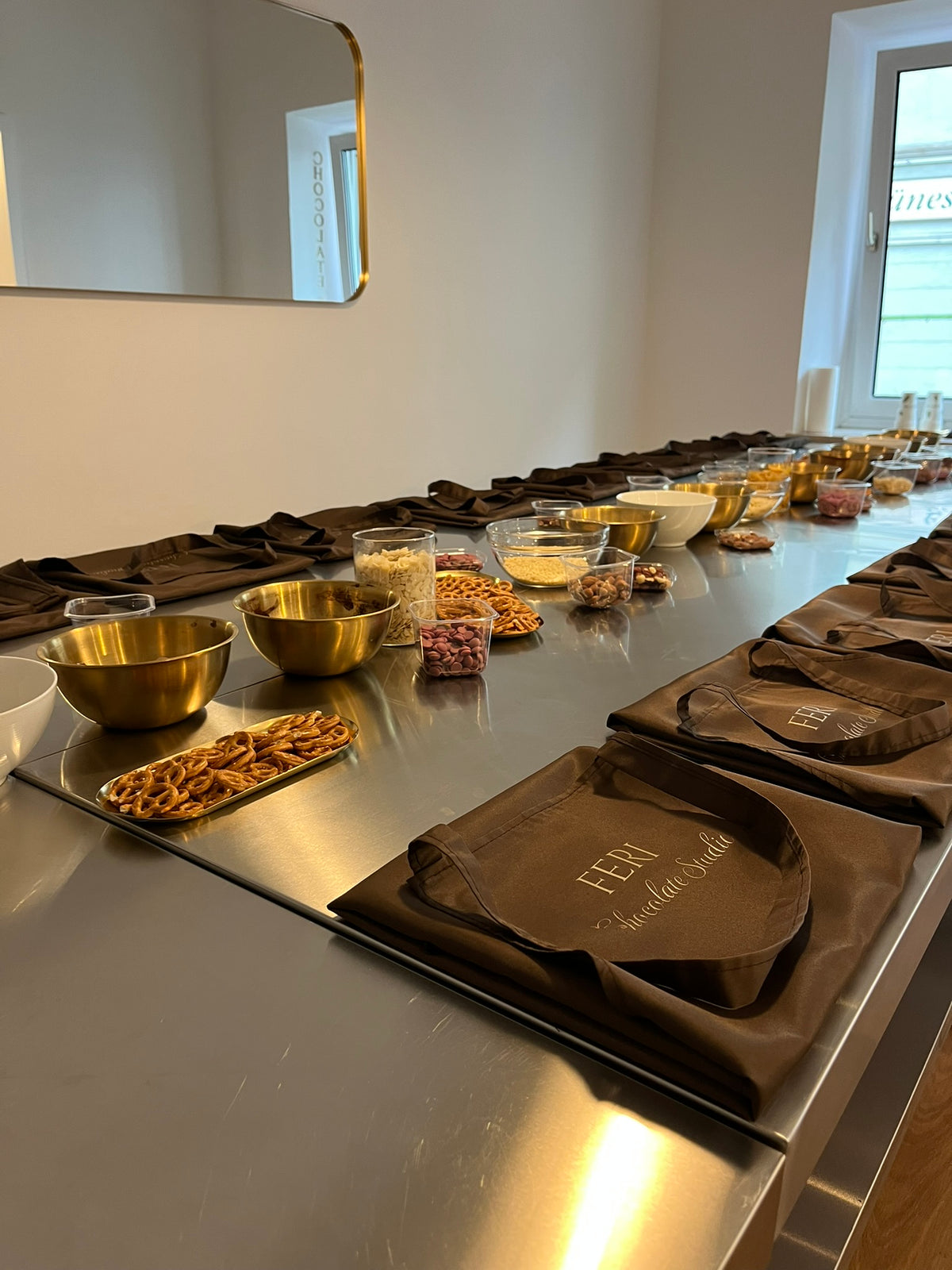 Eingedeckter Zutaten-Tisch mit Toppings und gefalteten FERI-Schürzen vor Workshopbeginn